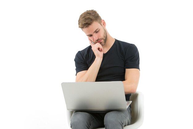 Dovrei saltare questo. Uomo con la faccia annoiata del computer portatile che guarda la pubblicità. Ragazzo bello con la barba lunga in camicia nera funziona computer isolato bianco. Uomo stanco dei fastidiosi video pubblicitari.