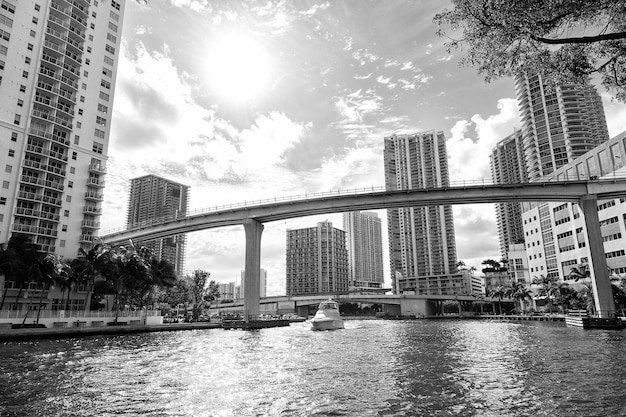 Downtown Miami lungo l'insenatura del fiume Miami con Brickell Key sullo sfondo e yacht in crociera oltre il ponte