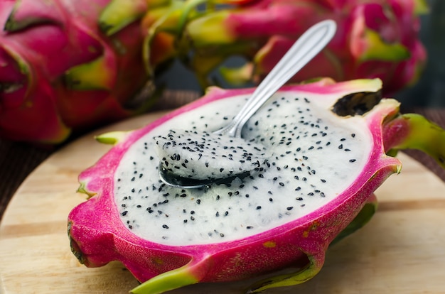 Dragomfruit mezzo bianco con il cucchiaio sul tagliere