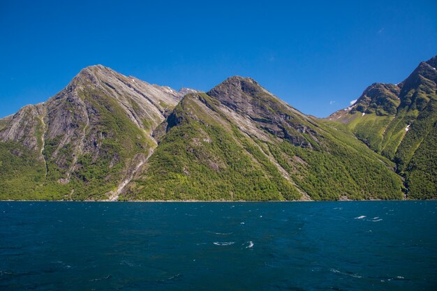 Drammatico paesaggio soleggiato e di bellezza a Hjorundfjord, Norvegia