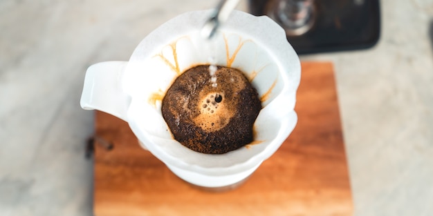 Drip coffee, barista versando acqua sul caffè macinato con filtro, erogazione del caffè