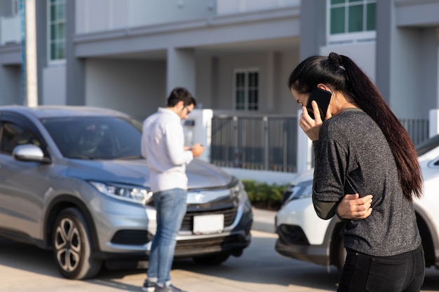 Driver della donna caucasica che fa telefonata all'agente di assicurazione dopo incidente stradale. Incidente. Assicurazione auto un concetto di assicurazione contro i danni.