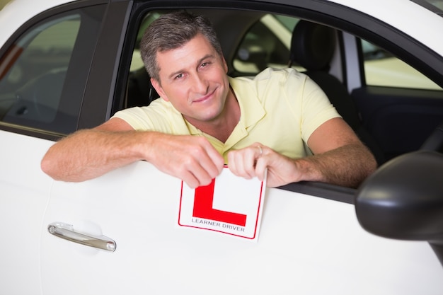 Driver maschio allegro che strappa il suo segno di L