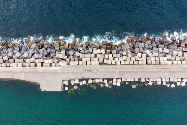 Drone aereo che vola frangiflutti di pietra nel mare