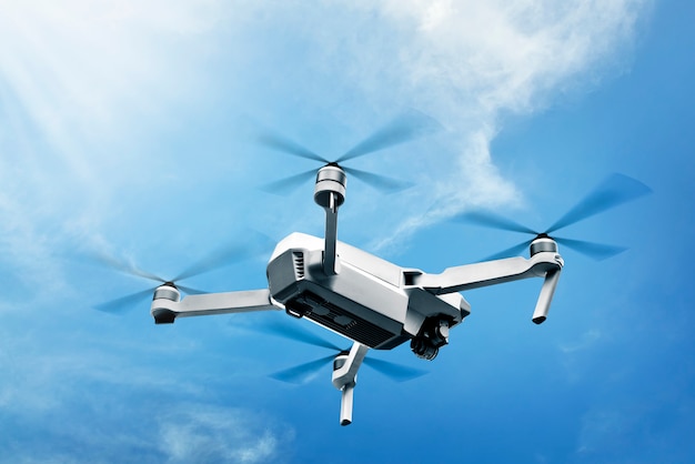 Drone bianco con telecamera che vola in aria