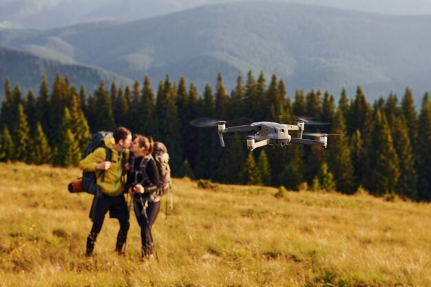 Drone che vola vicino a giovani viaggiatori Maestose montagne dei Carpazi Bellissimo paesaggio di natura incontaminata