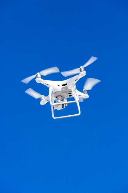 Drone Quadcopter con la fotocamera contro il cielo blu