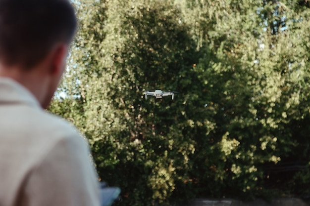 Drone quadrocopter controlla dalle mani dell'uomo all'aperto. Giovane che rilascia elicottero aereo per volare con una piccola fotocamera digitale volante. Concetto di tecnologia moderna nella nostra vita. Copia spazio per il sito