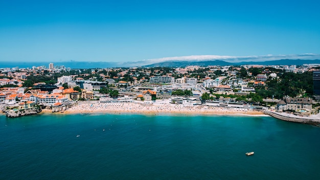 Drone vista aerea di bagnanti non identificabili sulla spiaggia di Praia da Conceicao a Cascais in Portogallo