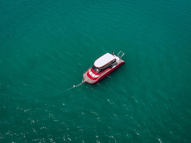 Drone vista del piccolo motoscafo bianco e rosso nuovo di zecca nel mare blu, brilla sotto il sole splendente; concetto di navi.