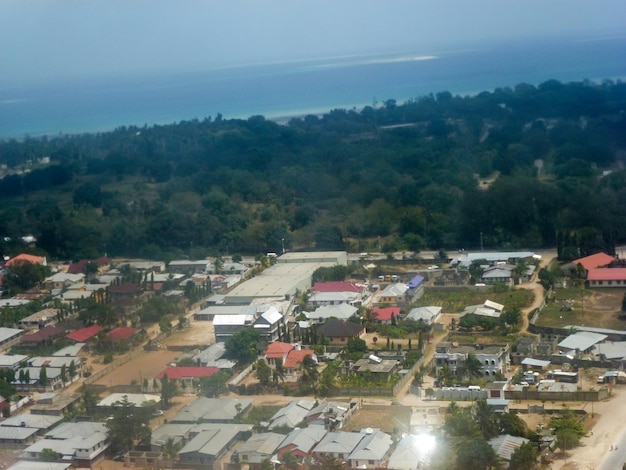 Drone vista della foresta di piccoli edifici della città e la costa del mare in lontananza