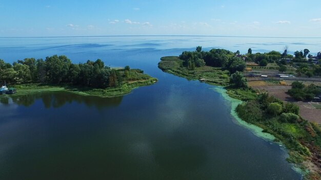 Drone vista isola e campo agricolo sulla riva Mare blu su chiara vista dell'orizzonte