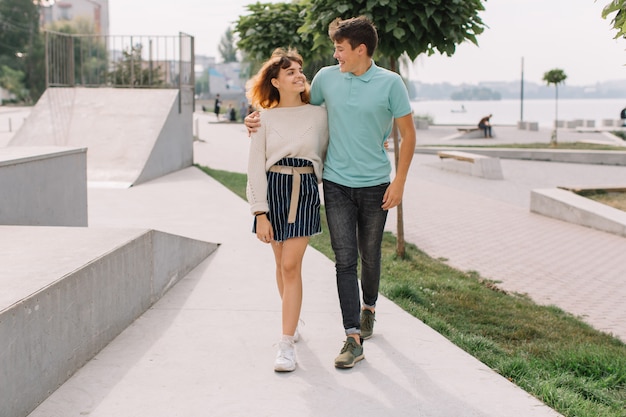 Due adolescenti, ragazzo e ragazza nel parco e parlando e scherzando.