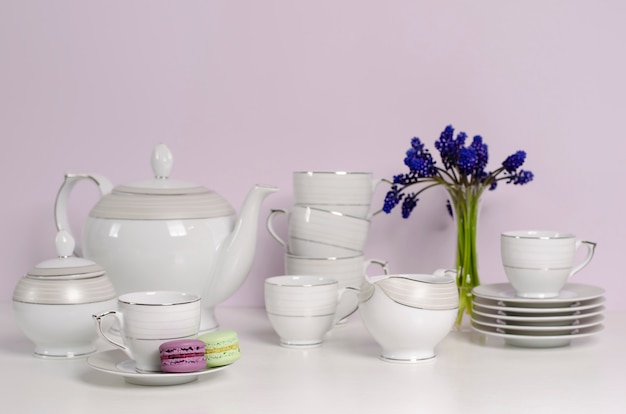 Due amaretti e porcellana o stoviglie tè e caffè con fiori blu sul tavolo bianco.