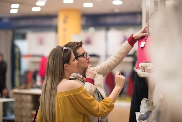 Due amiche a fare shopping a piedi nel centro commerciale con borse e scelta