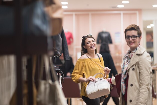 Due amiche a fare shopping a piedi nel centro commerciale con borse e scelta