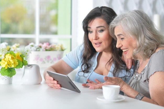 Due amiche anziane con un tablet al tavolo