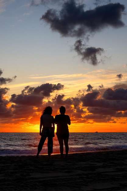 Due amiche che guardano il tramonto sulla spiaggia