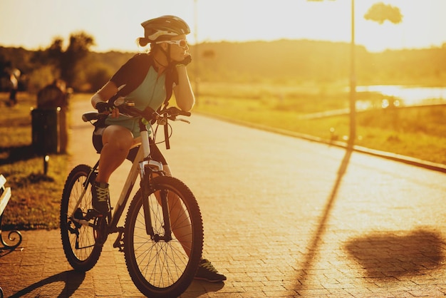 Due amiche che guidano sulle bici al tramonto