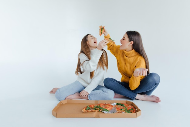 Due amiche che mangiano pizza