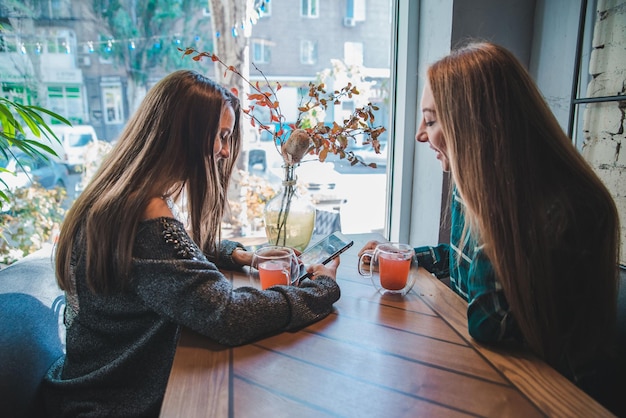 Due amiche che parlano al bar mentre bevono un tè. concetto di riunione