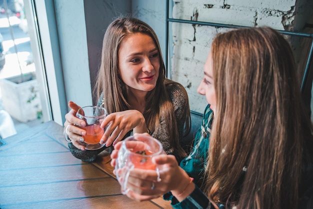 Due amiche che parlano nella caffetteria mentre bevono un incontro di tè