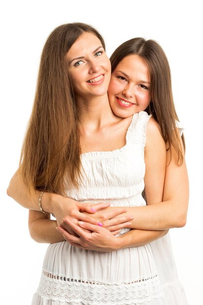 Due amiche che ridono con denti bianchi perfetti con uno sfondo verde