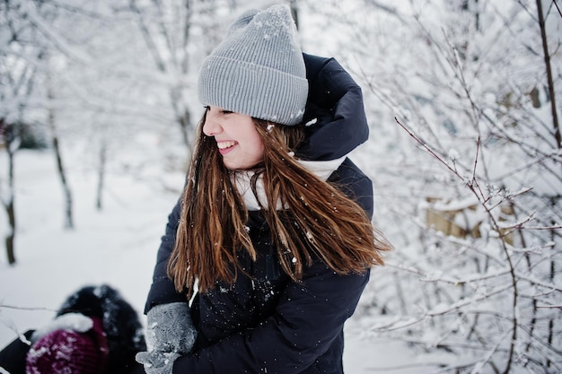 Due amiche divertenti che si divertono al giorno di neve invernale vicino agli alberi coperti di neve.