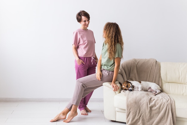 Due amiche o sorelle a casa con il loro simpatico cane. Quarantena, isolamento, mondo pandemico di coronavirus. Resta a casa.