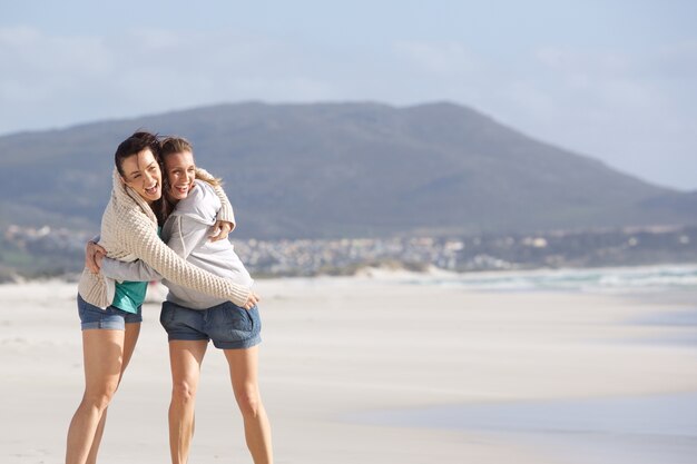 Due amiche ridenti in spiaggia