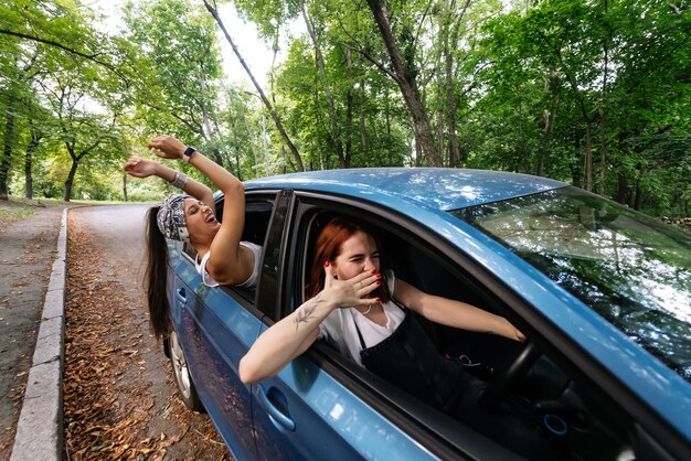 Due amiche scherzano e ridono insieme in macchina