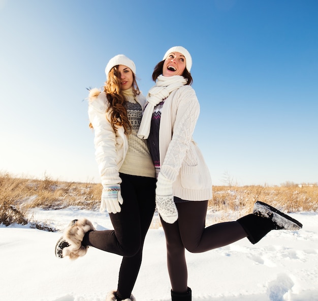 Due amiche si divertono e si godono la neve fresca in una bella giornata invernale