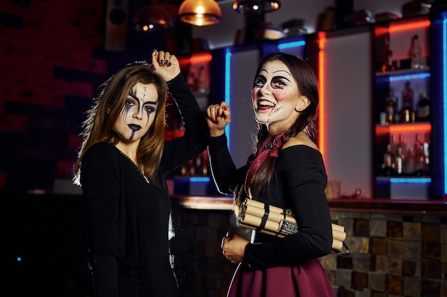 Due amiche sono alla festa di halloween a tema con trucco e costumi spaventosi con bomba a orologeria.