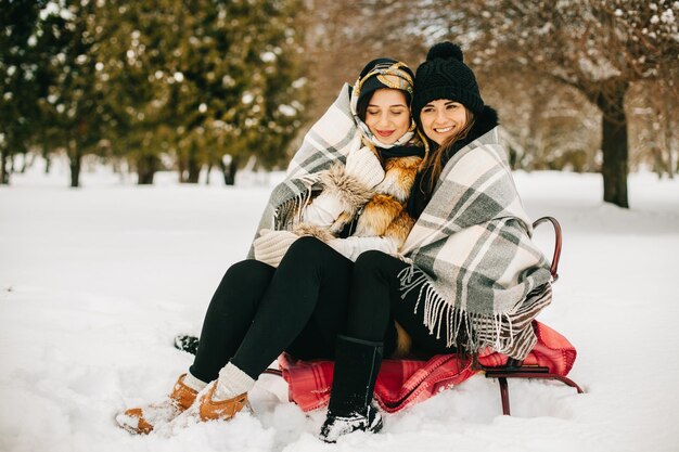 Due amiche sulle slitte in inverno