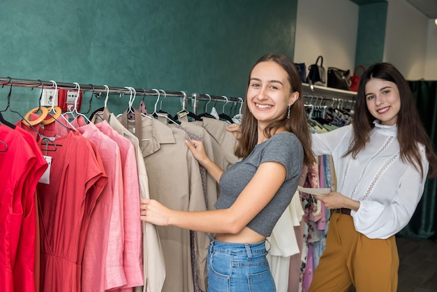 Due amichevoli ragazze che trascorrono del tempo per lo shopping nel negozio di moda. stile di vita