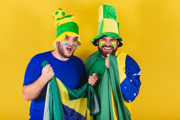 Due amici brasiliani tifosi di calcio brasiliani vestiti per tifare in un campionato