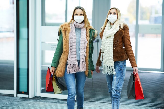 due amici che fanno shopping insieme indossando una maschera, concetto di coronavirus