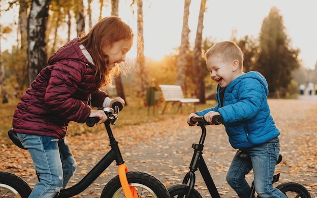 Due amici che fanno una passeggiata serale in un parco con le loro biciclette stanno giocando allegramente senza preoccuparsi di nulla