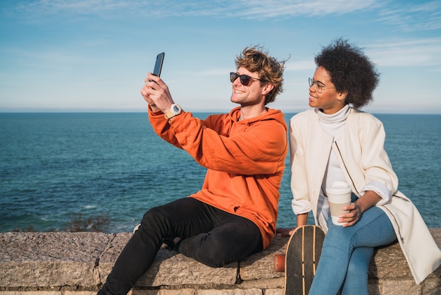 Due amici che prendono un selfie con smartpone.