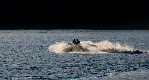 Due amici che si godono lo skid d'acqua ad alta velocità sulla spiaggia di Boiro