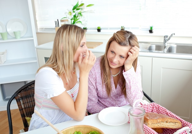 Due amici femminili vicini che parlano insieme nella cucina