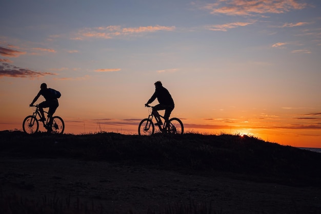 Due amici in bicicletta si godono uno splendido tramonto