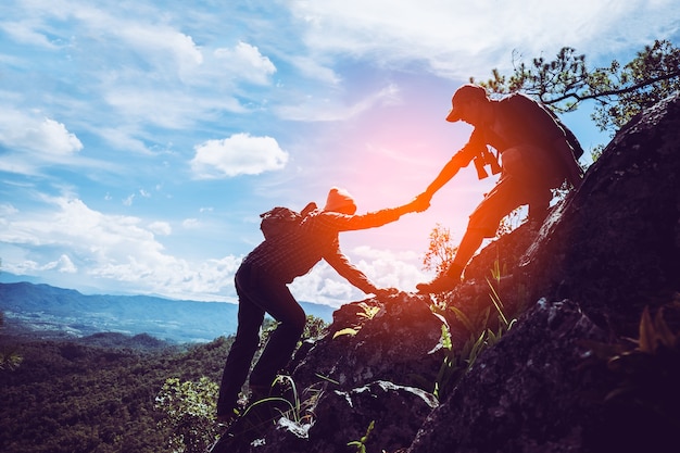 Due amici si aiutano a vicenda e con il lavoro di squadra cercano di raggiungere la cima delle montagne.