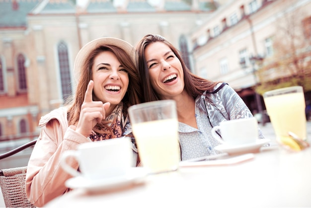 Due amici si divertono in un caffè soleggiato