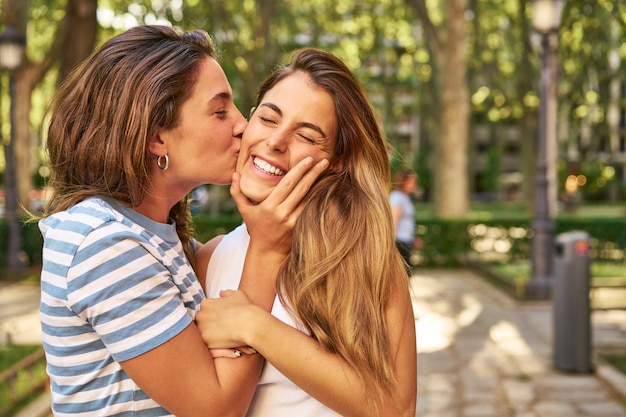 Due amici si scambiano un bacio in un parco