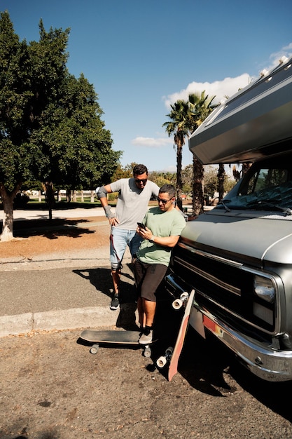 Due amici skateboarder che chiacchierano vicino al loro camper a gran ganaria