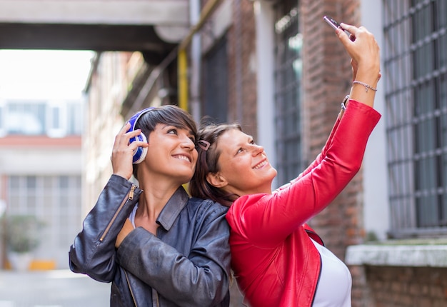 Due amici stanno prendendo un selfie in una strada urbana
