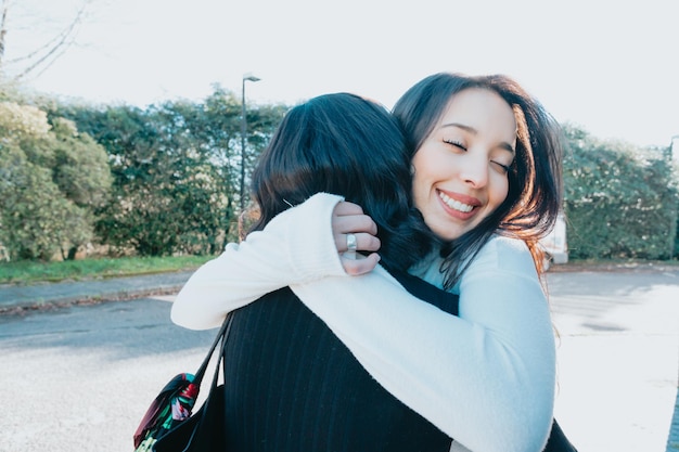 Due amici studenti universitari che si abbracciano felici dopo essersi incontrati di nuovo al campus dopo le vacanze. Abbraccio adorabile concetto. Studia e impara insieme il concetto. Ritorno a scuola e in classe.