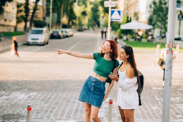 Due amici turisti che consultano una guida online su uno smartphone per strada