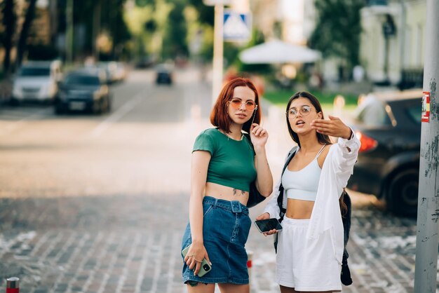 Due amici turisti che consultano una guida online su uno smartphone per strada